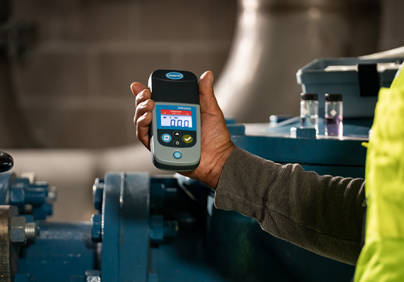 A water quality professional using a Hach pocket colorimeter.