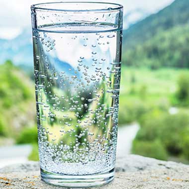 A clear glass of water highlights that water quality monitoring is important for human health. Clarity is deceptive and monitoring hardness guards against iron and copper corrosion.