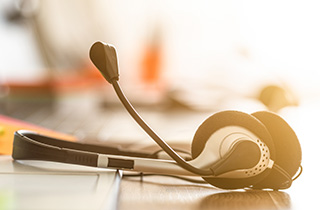 A headset with a microphone resting on a desk.