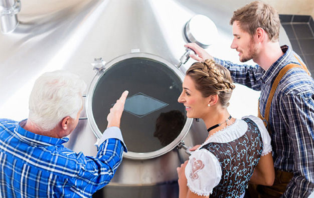 A group discussion around a conical fermenter.